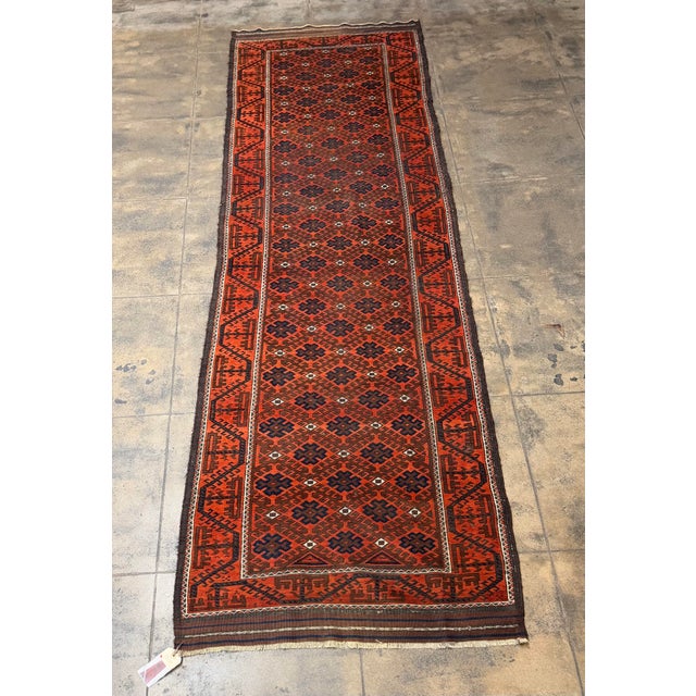 Dating to approximately 1900, this antique Baluch tribal runner is distinguished by its beautifully repetitive geometric...