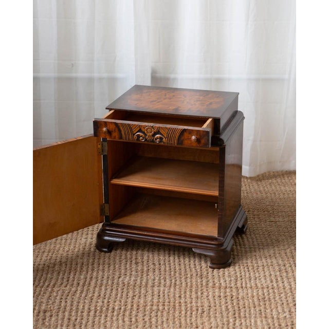This Art Deco nightstand features a striking burlwood pattern with dramatic chevron grain patterns and warm, rich tones....