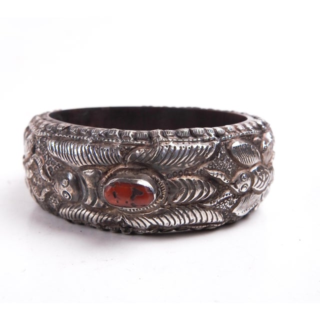 Vintage sterling silver repousse work bangle with three bezel set red coral pieces. Silver is an old piece which has been...
