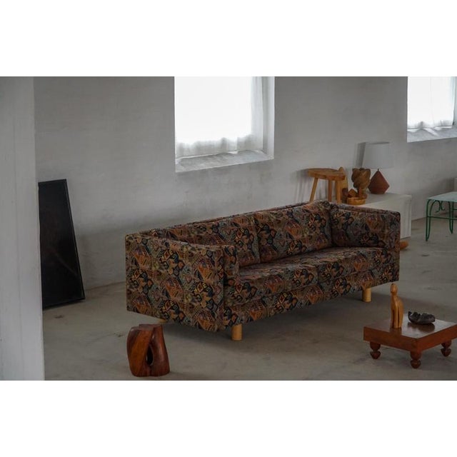 This classic Danish modern sofa features a clean, timeless design with loose cushions and visible light wooden round legs,...