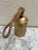 Rustic gold toned metal large cowbell with rope handle. Fun farmhouse or cabin accent for indoor and outdoor decor.