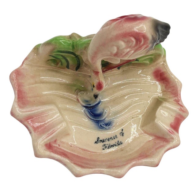 Mid-century Era pink and green "Soweru of Florida" ceramic ashtray with a drinking flamingo. The ashtray features a...
