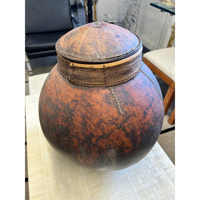 Impressive in scale, large hand made organic hollowed out dried gourd vessel with lid and wood. Visible stitching and...
