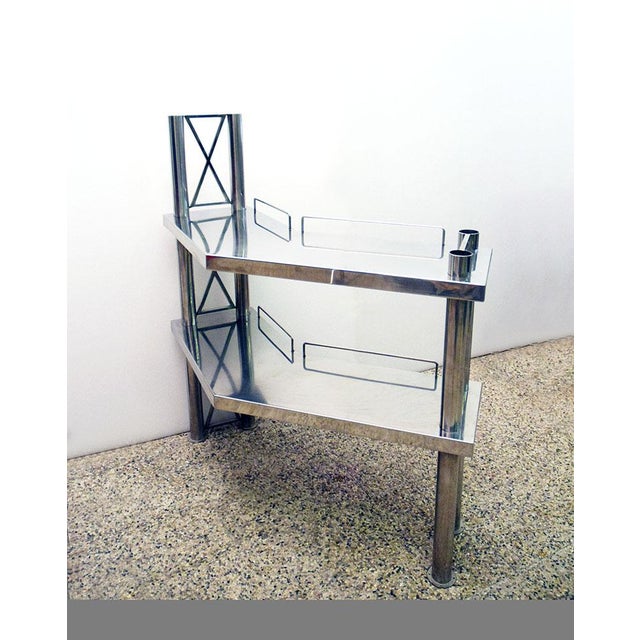 Console in polished steel, Italian production from the 70s. Composed of two trellis columns and two corner shelves, ideal...