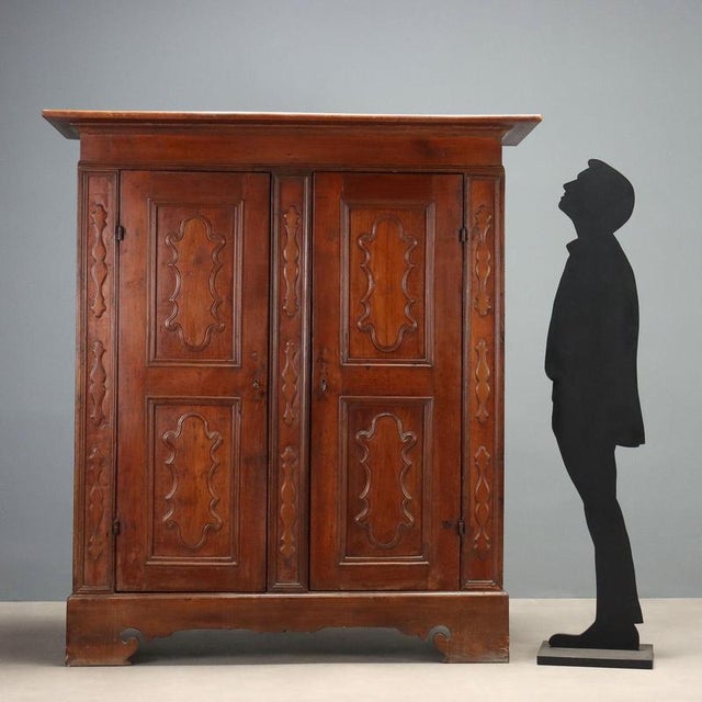 Baroque cherry wardrobe from Piacenza, dating back to the first half of the 18th century. The front features a pair of...
