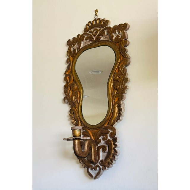 A carved and painted mirror with candle bracket. In the Florentine style. Italian circa 1930.