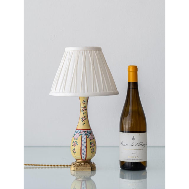 A small antique porcelain table lamp, beautifully hand-painted in a famille jaune inspired Chinoiserie style, featuring...