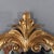 An antique French Louis XIV style wall mirror, crafted circa 1930, presents a magnificent example of Rococo Revival...