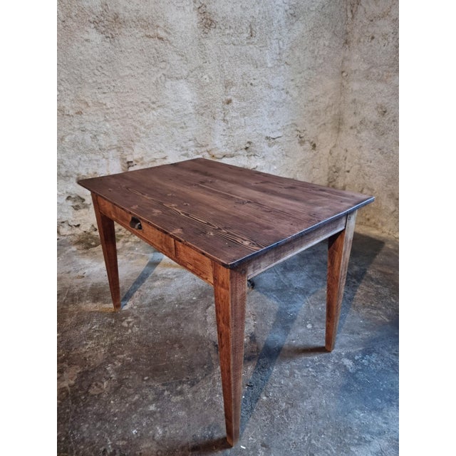 This antique French table dates from circa 1920 and features a solid pine top combined with an oak base and legs. The...
