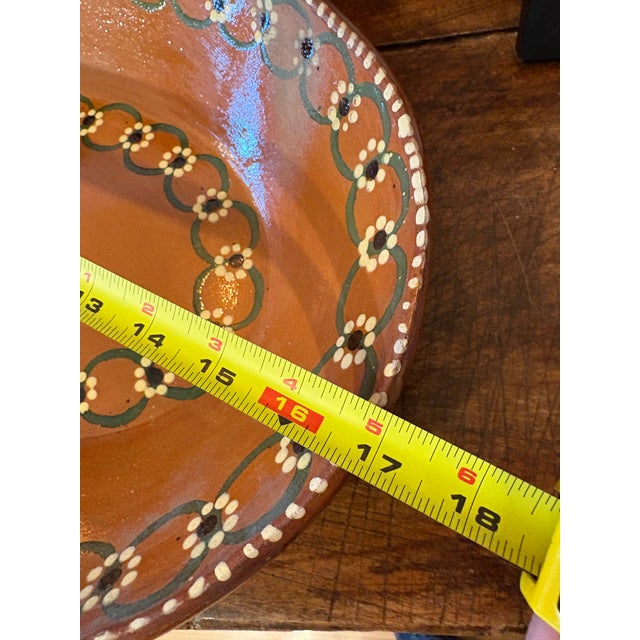 Handshaped and handpainted Mexican serving tray with green, black and cream painted details .
