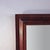 An antique Empire style mirror, dating to approximately 1840, crafted from rich flame mahogany. This substantial wall...