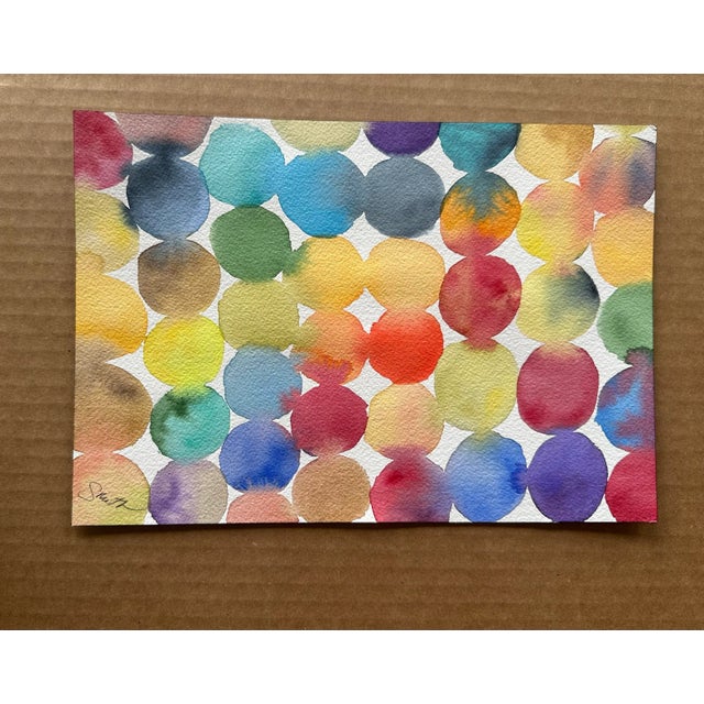 A fun and colorful abstract watercolor featuring overlapping circles in a spectrum of bright, cheerful hues. This modern,...