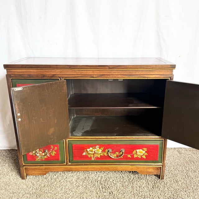 This vintage Chinese sideboard showcases richly hand-painted panels in deep red tones, adorned with traditional floral and...