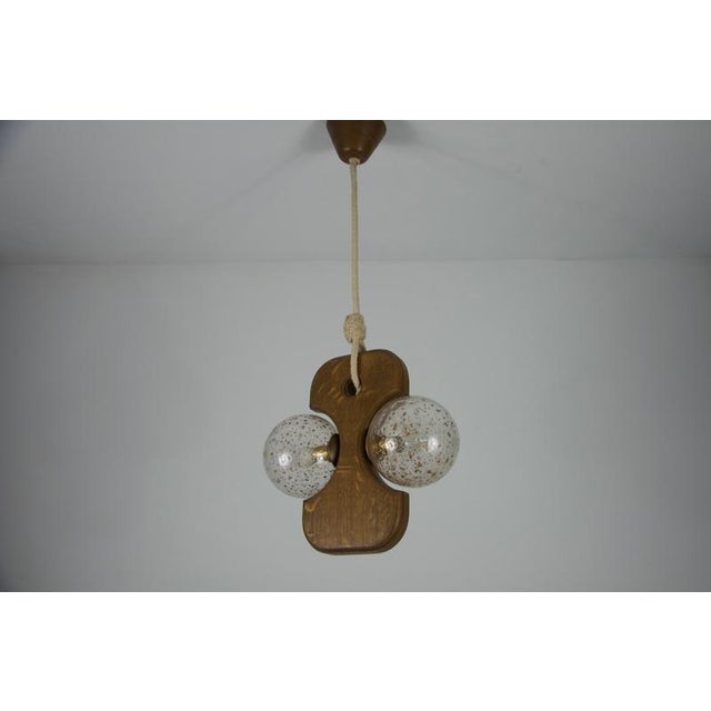 This hanging lamp by temde from the 1960s is a striking example of mid-century modern design. It features a unique,...