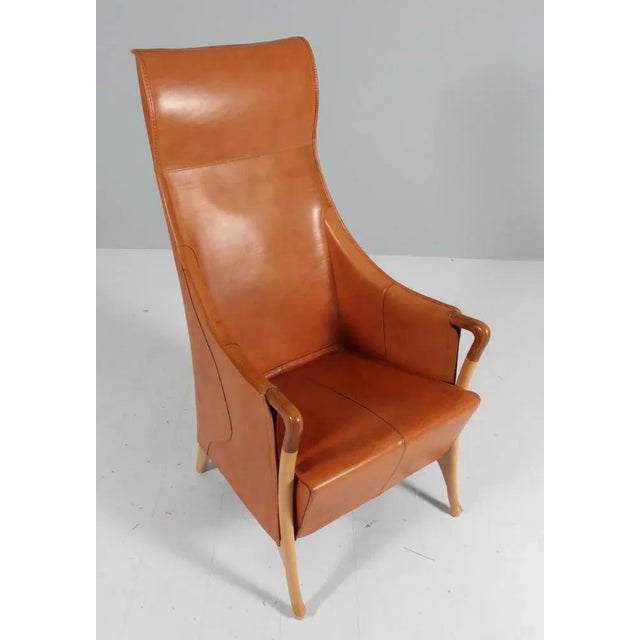 Umberto Asnago for Giorgetti. Lounge chair in patinated saddle leather Frame of beech and armrest details in walnut. Made...