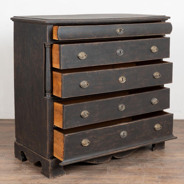 Large black pine chest of five drawers with turned columns flanking the inset upper large two drawers. The four large...