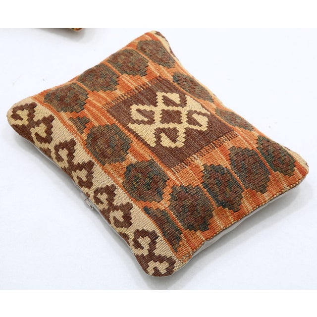 A one-of-a-kind handwoven Afghan wool kilim lumbar pillow featuring rosette border with a central medallion. Cut and sewn...