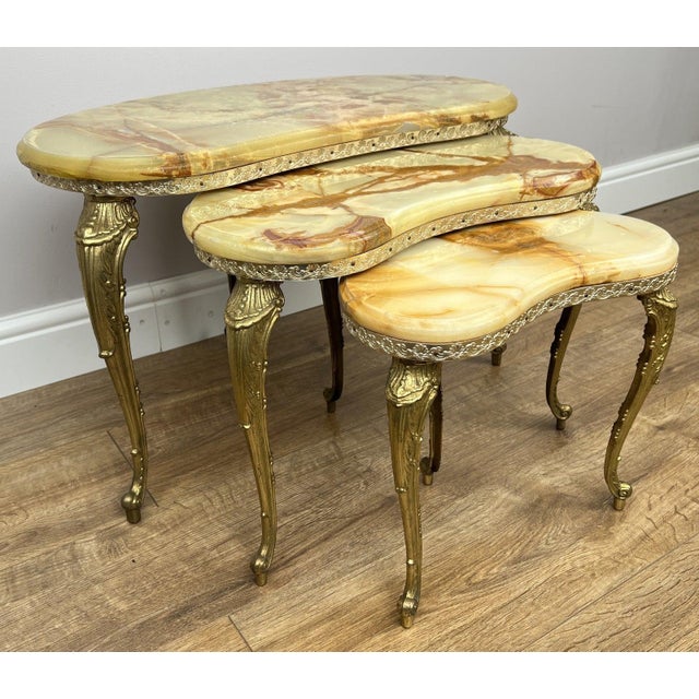 A stunning set of Vintage French marble onyx and brass nesting tables , beautifully crafted with elegant kidney-shaped...