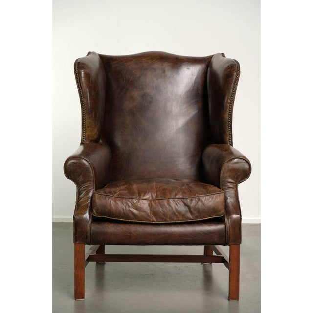 This vintage English-style wingback chair is made of grained cowhide leather and features a comfortable seat. It is...
