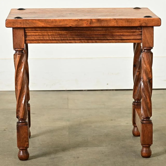 Dimensions: 17 ¼” H x 18 ⅛” W x 13 ¾” D A delightful French walnut footstool, early 20th century, with stylized barley...