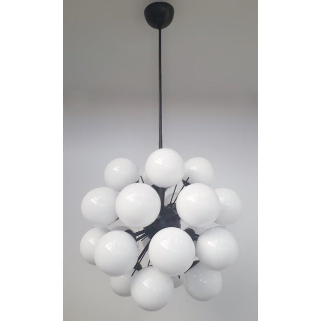Italian sputnik chandelier with 24 glossy white Murano glass globes mounted on black powder coat finish frame / Made in...