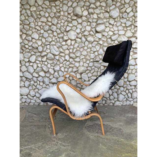 Pernilla Lounge Arm chair. The seating surface consists of woven webbing slung between a frame of steam-bent beech. This...