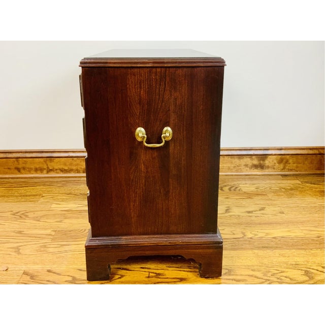 A vintage Chippendale-style four-drawer chest mahogany with a molded top edge, graduated drawers with brass oval-backplate...