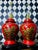 Pair of vintage chinoiserie table lamps featuring red lacquered ceramic bodies with raised landscape and pagoda motifs...