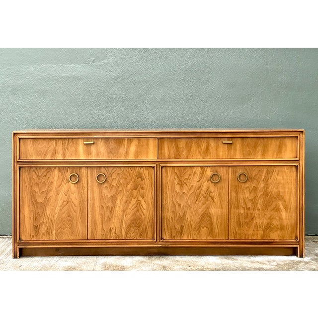 This vintage campaign credenza pairs warm walnut with crisp brass hardware, a combination that blends the clean,...