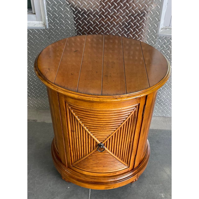 Vintage Lexington Tommy Bahama “Cayman” drum table featuring a warm honey-toned finish with woven rattan panels and a...