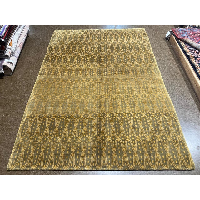 Hand-knotted Nepal wool and silk rug featuring an allover repeating pattern of elongated oval and linear motifs on a muted...