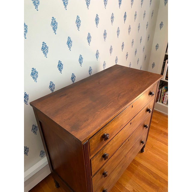 This walnut chest projects an understated beauty with reeding one either side of the drawers and turned feet. On first...