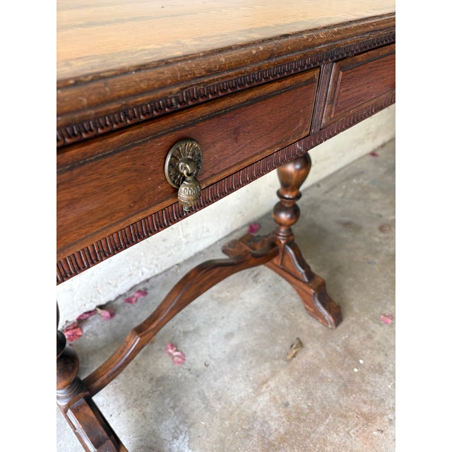 A beautifully proportioned antique writing table featuring classic early 20th-century English craftsmanship. This elegant...