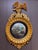 A large and impressive English Regency period carved giltwood convex mirror with a spread wing eagle perched on a stepped...