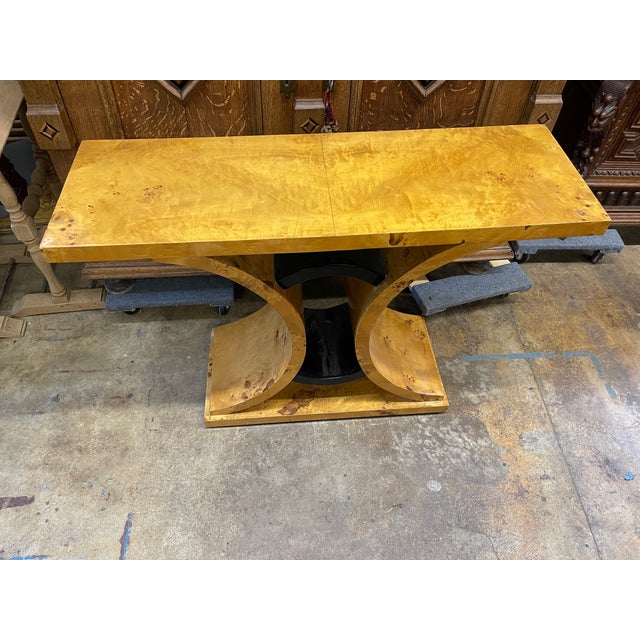 Art Deco Wall Console with geometric curves and high symmetry. Finish is a swirling burl pattern with black ebonized accents.