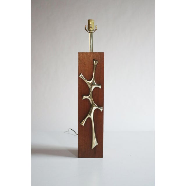 Moderist table lamp in walnut wood with a sculptural brass emblem in the style of Maurizio Tempestini.