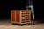 Vintage rolling wooden parts cabinet. This piece features 12 drawers of uniform size, and a gray frame with red drawers...