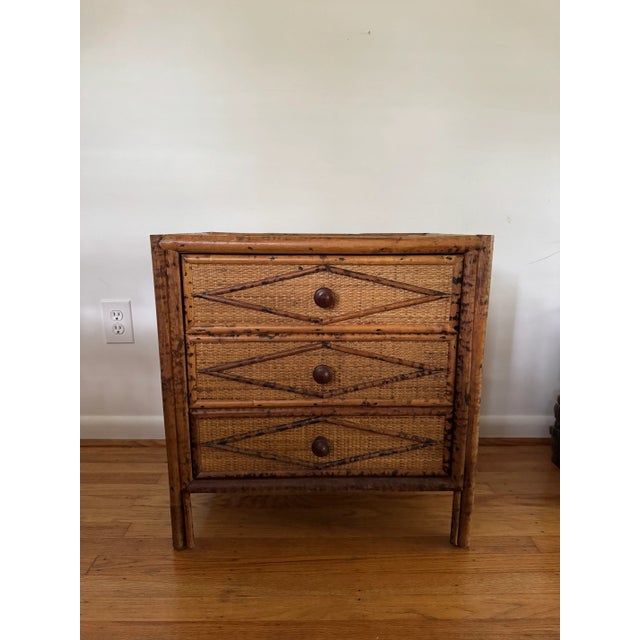 Vintage three drawer burnt bamboo and rattan night stand or chest. Classic materials with a diamond recurring pattern on...