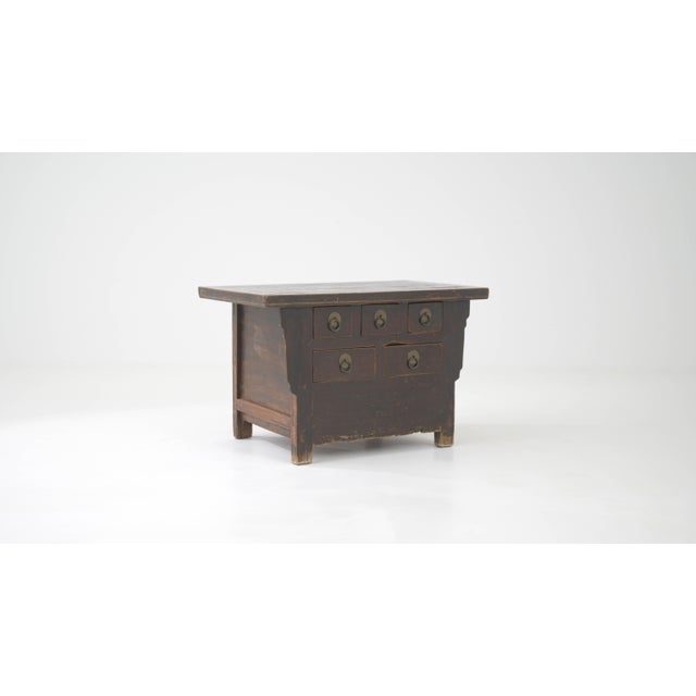 This 19th-century Chinese wooden chest of drawers is a magnificent example of traditional Eastern craftsmanship....