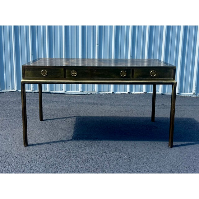 Incredible vintage Mastercraft desk in antique brass with tooled leather top . Three drawers with stylized campaign...