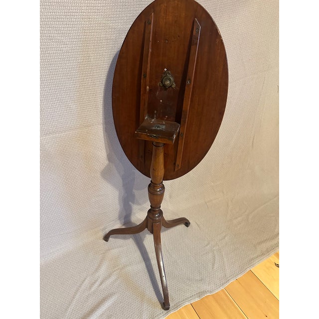 Early American Tilt top table constructed of mahogany wood in a graceful Federal style. This table includes a tilt-top...