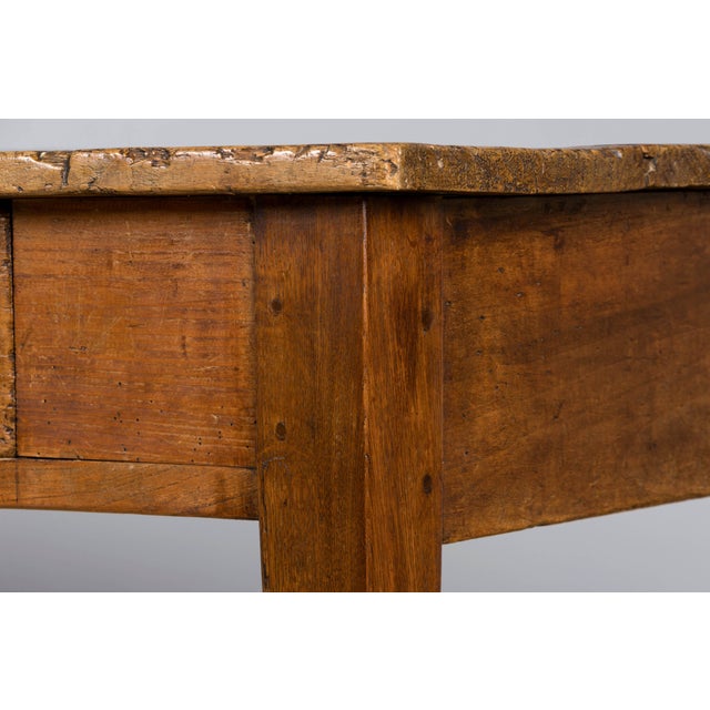 An early 19th-century French Provincial farmhouse table, sourced in Provence, France. Crafted from solid fruitwood, this...