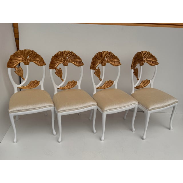 Set of four Hollywood Regency chairs with carved and gold leaf lotus flowers and newly upholstered in soft textured...