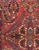 An antique Persian Sarouk rug from western Iran, featuring an elaborate floral composition with stylized palmettes,...