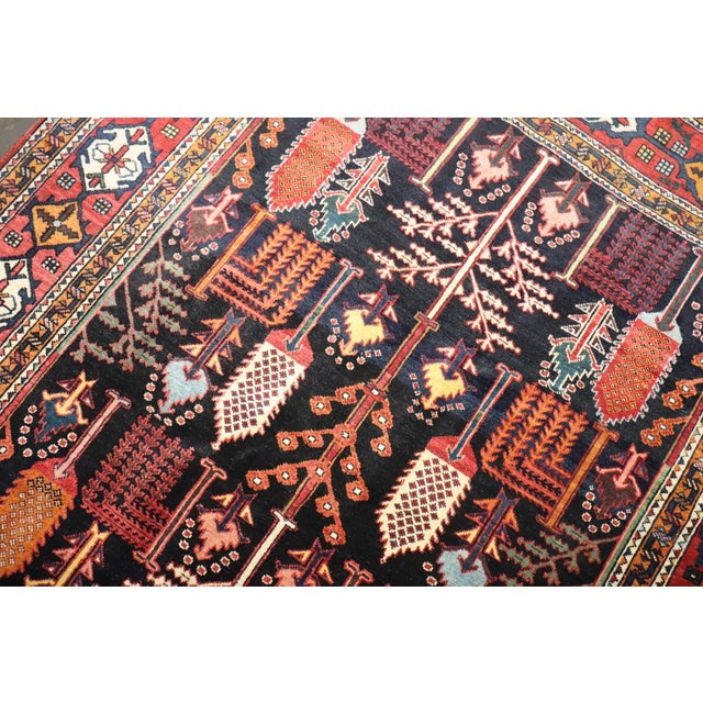 A 2nd quarter of the 20th century Persian Bakhtiari rug featuring a tree of life design on a navy field