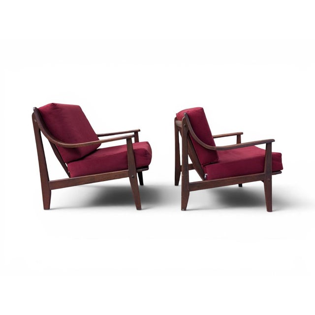 This pair of armchairs perfectly embodies Midcentury Modern design, featuring a wooden frame with warm, organic lines...