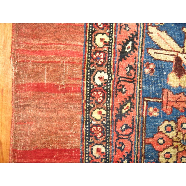 Traditional room size Persian Bidjar rug with a large navy medallion on a soft brick red field and mustard color corner...