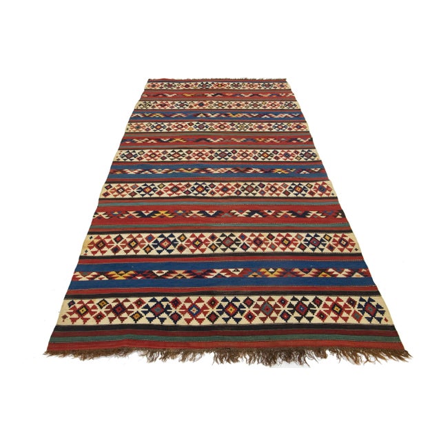 Introducing a stunning vintage kilim wool rug, meticulously hand-knotted with a captivating geometric design set against a...