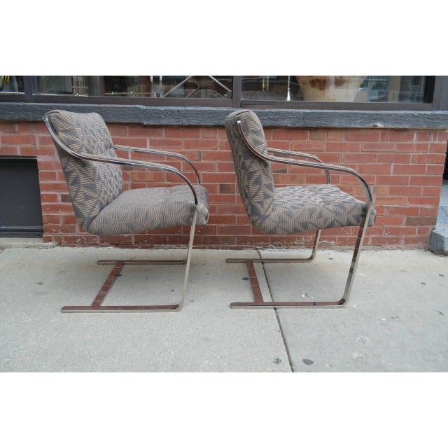 Eight finely crafted polished stainless steel and chrome dining chairs by Brueton. The chairs are cantilevered with...