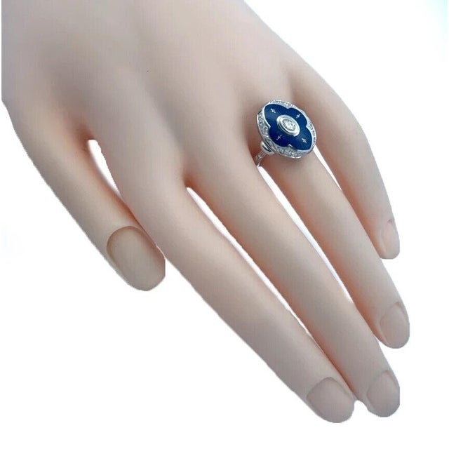 Authentic from Fabergé, this lovely oval top ring is crafted from 18k white gold featuring a floral shape diamond bezel...